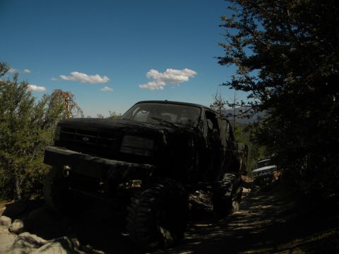 Black 1992 Ford Bronco on a rocky, wooded trail, front-left view