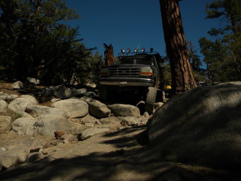Black 1992 Ford Bronco navigating a rocky trail, front view