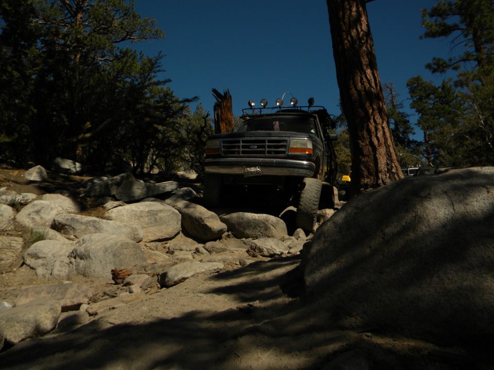 Black 1992 Ford Bronco navigating a rocky trail, front view
