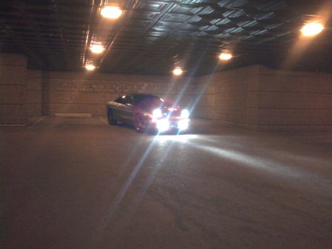 1994 Ford Probe - A car is parked inside a dimly lit structure with its headlights illuminated.