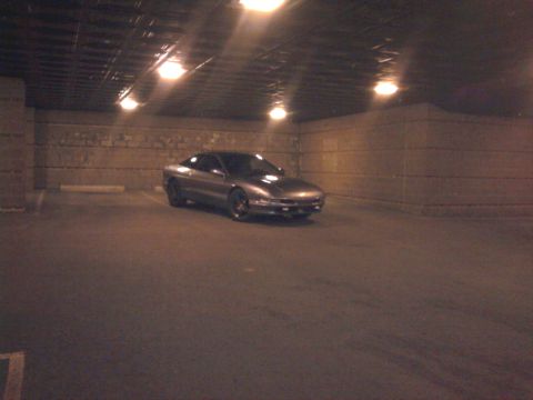 1994 Ford Probe - A silver coupe is parked in a garage with overhead lighting.