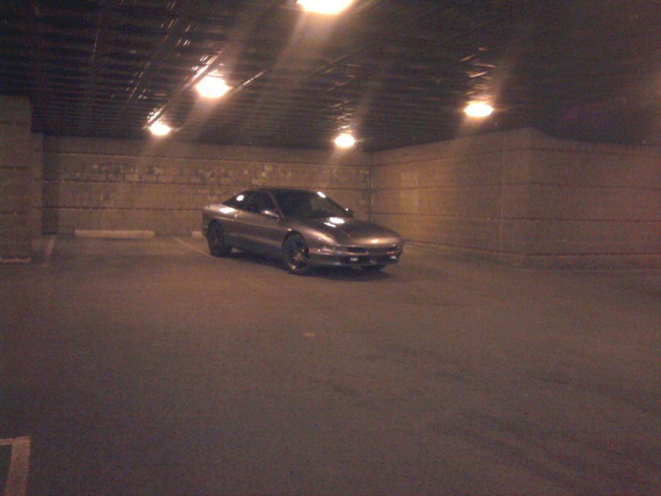 Silver coupe parked in a dimly lit garage, 3/4 front view