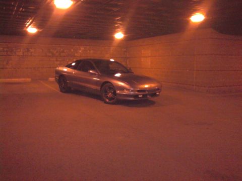 1994 Ford Probe - A 1994 Ford Probe is parked in a dimly lit garage with overhead lights.
