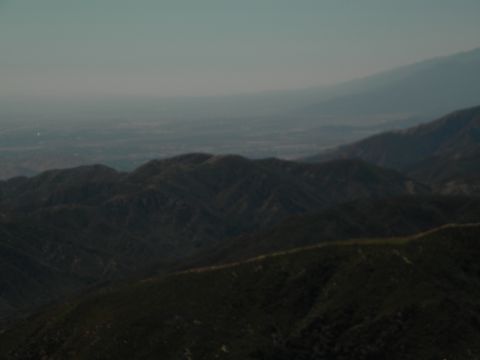 Misty mountain range with a distant valley and sky
