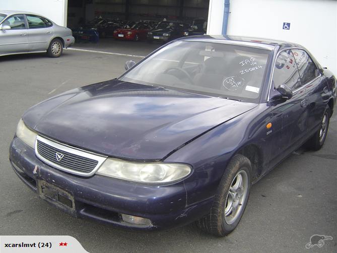 Dark blue Mazda Efini MS-8 sedan front 3/4 view with yard markings on windscreen