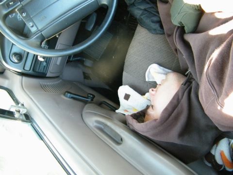 1982 Ford Bronco - Interior view of a car with a person sleeping in the passenger seat.