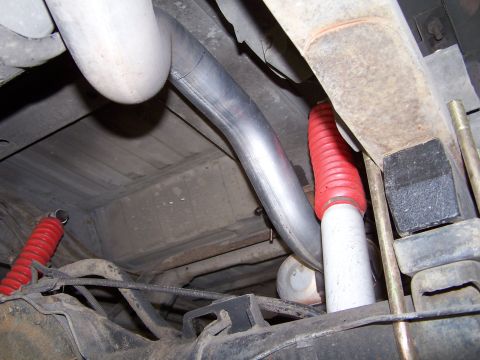 1989 Ford Bronco - Close-up of vehicle undercarriage showing exhaust system and suspension components.
