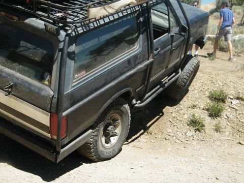 1982 Ford Bronco - This heavily modified SUV is equipped for off-road adventures with its extensive roll cage and roof rack system.