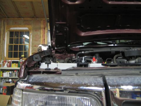 1996 Ford Bronco - Close-up view of a vehicle's engine bay with the hood raised, revealing the radiator and various engine parts.