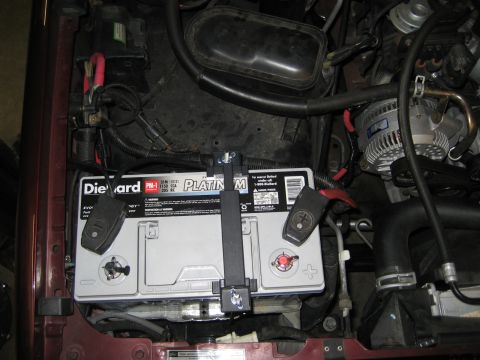 1996 Ford Bronco - Close-up view of the engine bay, focusing on the battery and alternator components.