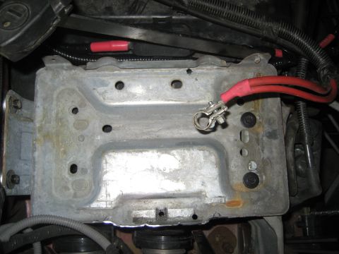 1996 Ford Bronco - Close-up view of a vehicle's battery tray and attached cables.