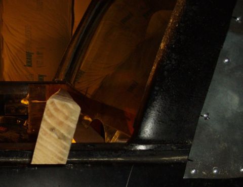 1978 Ford Bronco - The interior of a vehicle is shown with insulation and a wooden support piece visible.