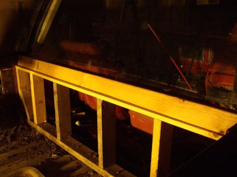 1978 Ford Bronco - Wooden framing is installed in the rear interior of a vehicle, obscuring the view of the back seat and window.