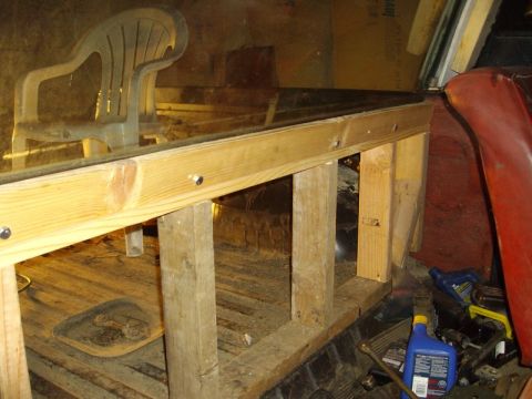 1978 Ford Bronco - Interior shot of a wood stud wall screwed together inside a truck bed, supporting a large pane of glass being dry-fitted as a rear window.…