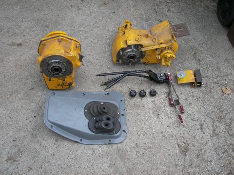 1988 Ford Bronco - Transfer case parts and linkage for a vehicle, laid out on a concrete surface.