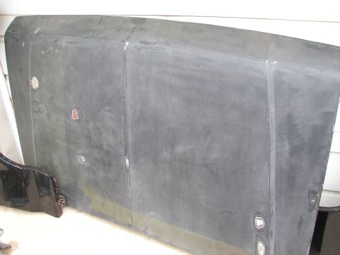 1988 Ford Bronco - A gray hood, likely for a vehicle, shows signs of repair and wear.