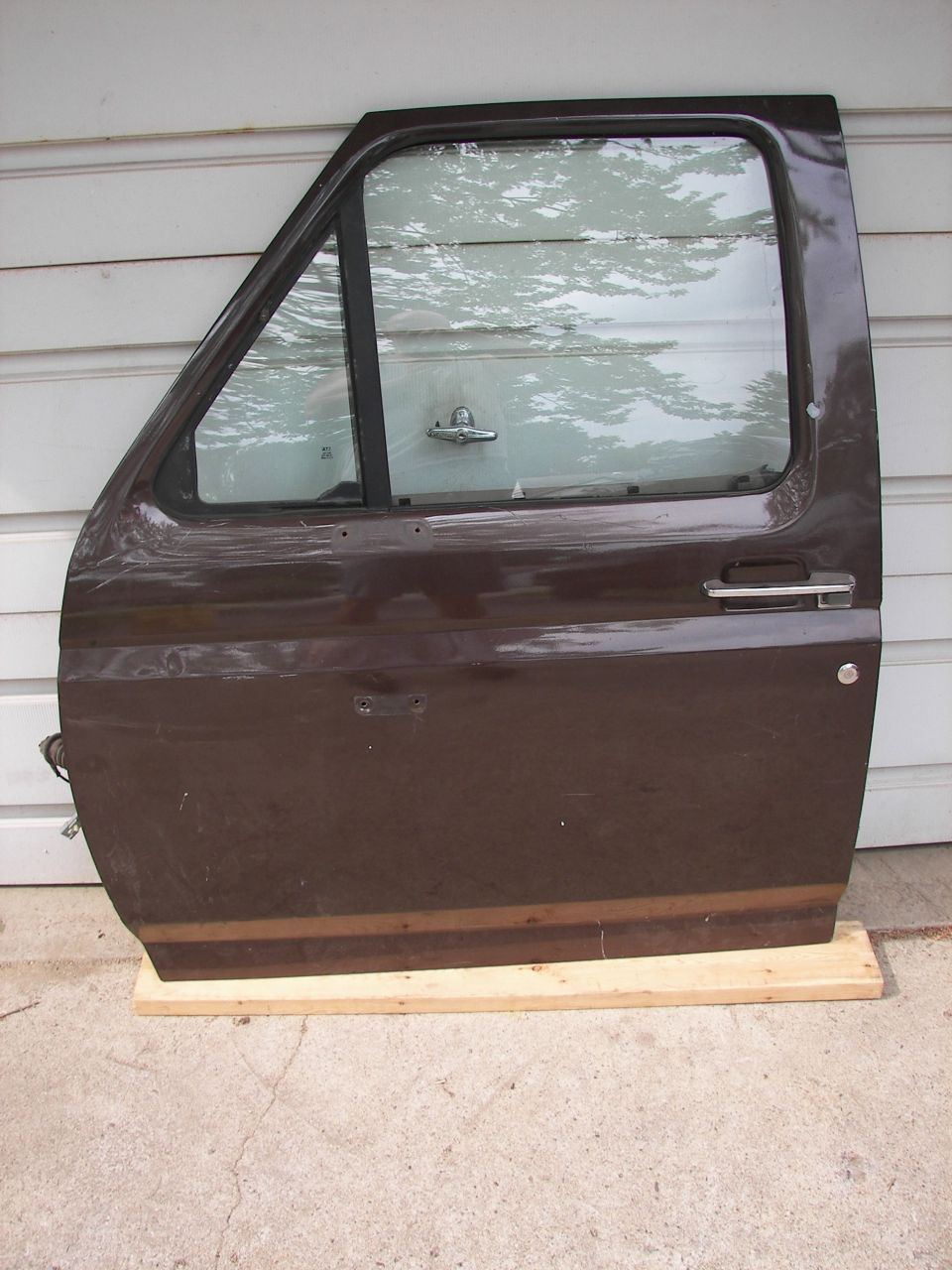 brown vehicle door with chrome handle and trim strip