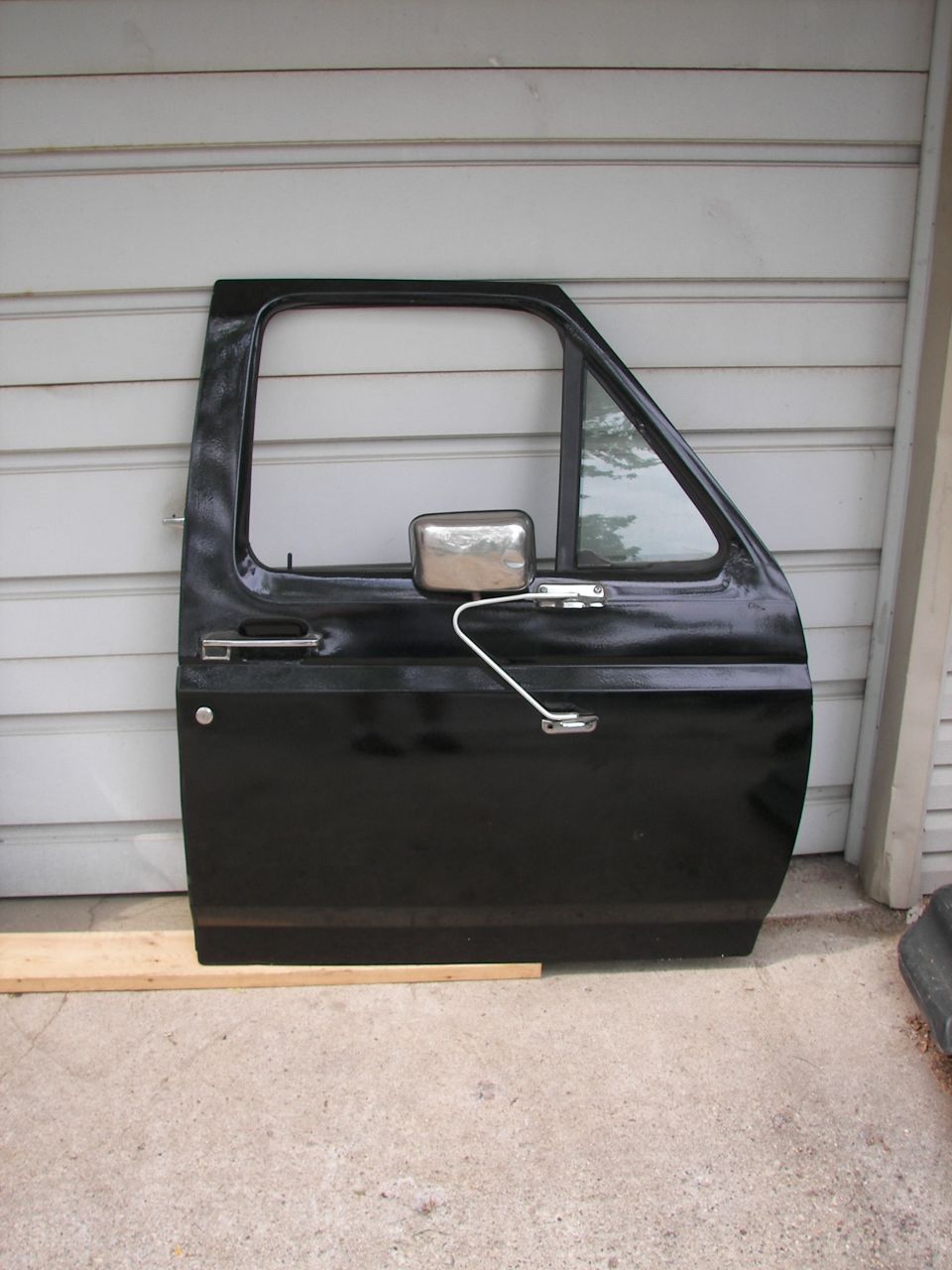 Black truck door with chrome side mirror and handle
