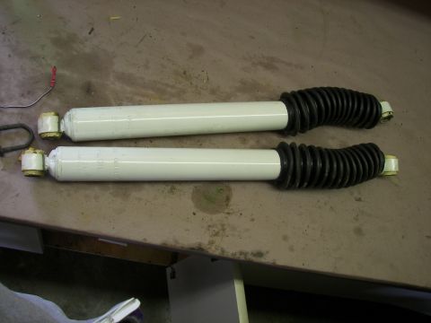 1988 Ford Bronco - A pair of shock absorbers are laid out on a surface, possibly for installation or sale.