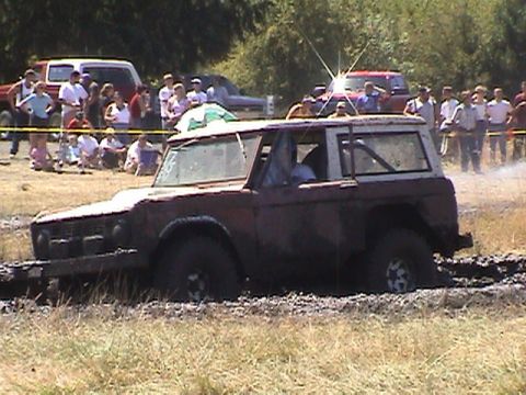 1994 Ford Explorer - A red Ford Bronco is stuck in the mud at a drag race event.