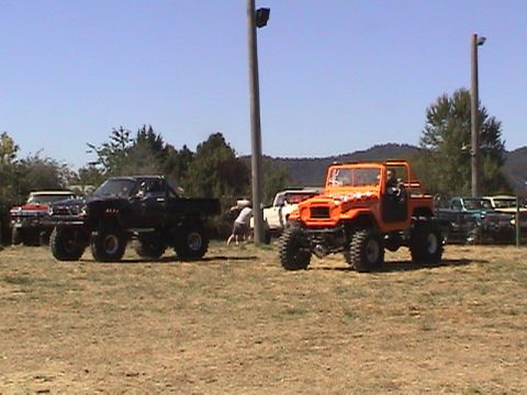 1994 Ford Explorer - Multiple modified trucks and SUVs gathered at an outdoor event on a sunny day.