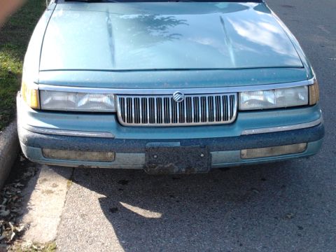 1993 Mercury Grand Marquis - Front view of a teal 1993 Mercury Grand Marquis, its distinctive chrome grille and rectangular headlights.