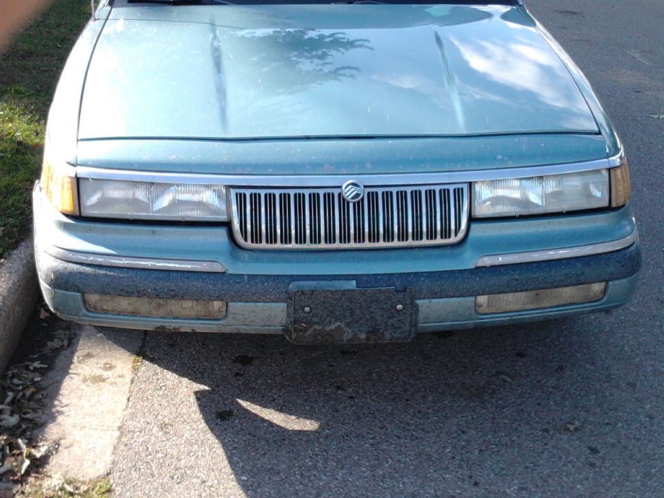 Teal 1993 Mercury Grand Marquis front end with chrome grille and rectangular headlights
