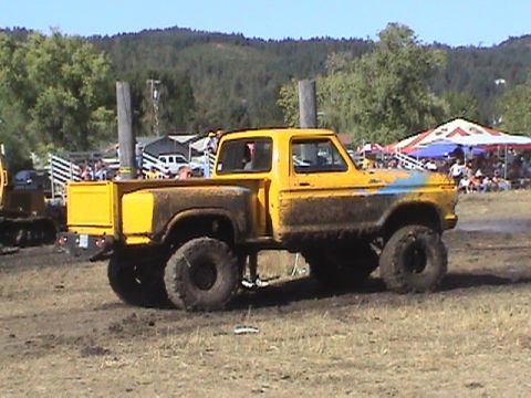 1994 Ford Explorer - A mud-covered yellow pickup truck competes in a drag race event.