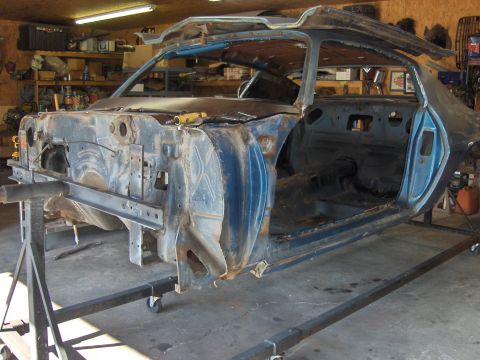 1979 Chevrolet Camaro - The stripped-down body of a classic car sits on repair stands in a workshop, awaiting restoration.