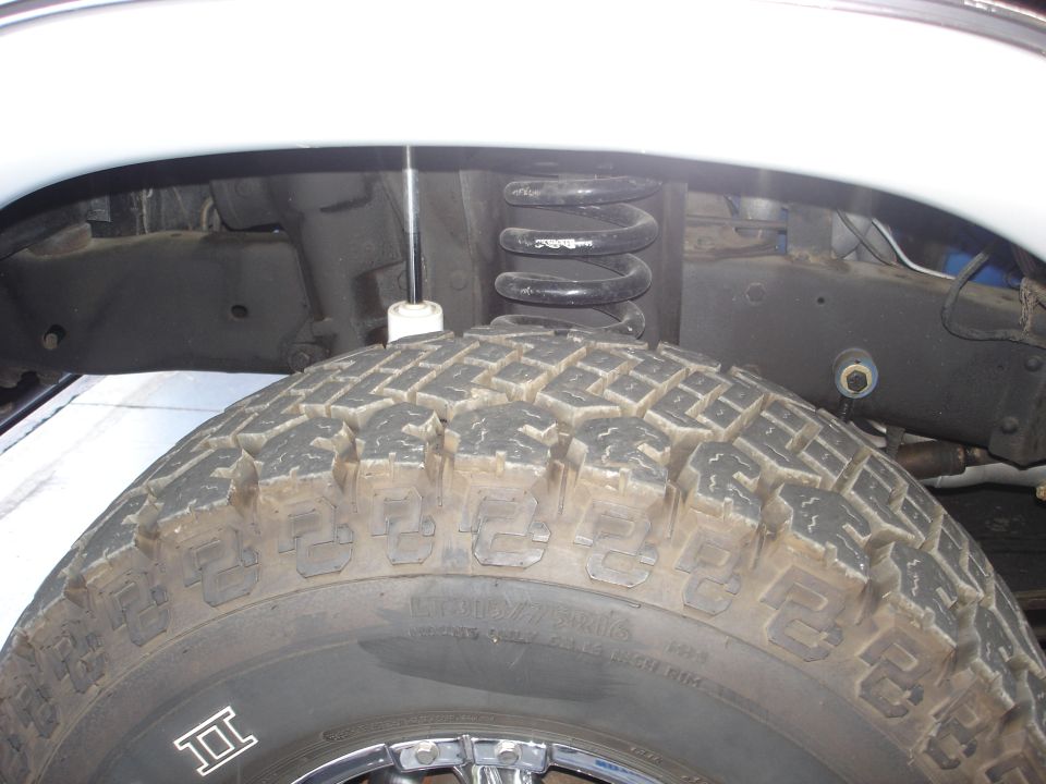Close-up of a tire and suspension system with a coil spring