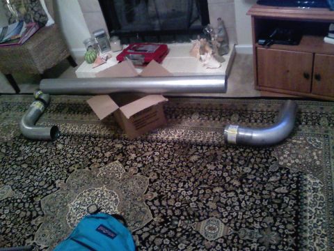 1990 Ford Bronco - Custom exhaust pipes are arranged on a patterned rug, ready for installation.