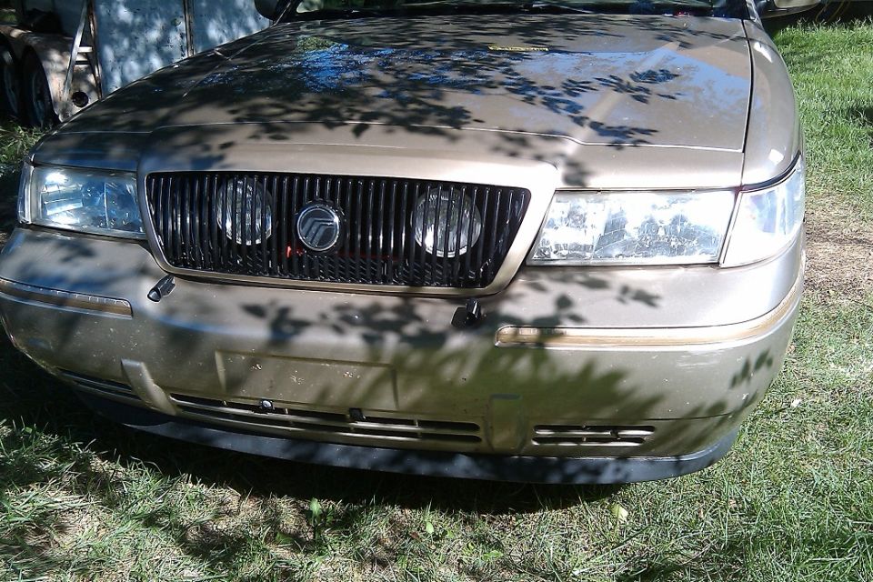 Gold 2000 Mercury Grand Marquis front grille with vertical slats and dual headlights