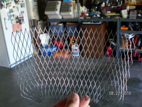 1996 Ford Bronco - Expanded metal mesh is held in front of a garage scene with shelves and a refrigerator.
