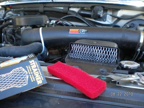 1996 Ford Bronco - Engine bay components and parts laid out on the hood of a vehicle.
