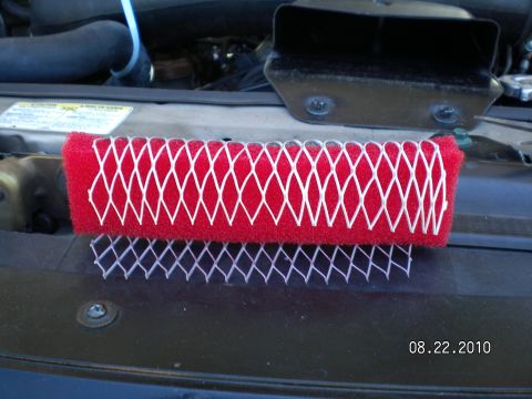 1996 Ford Bronco - Red air filter with white netting shown on a dark surface.