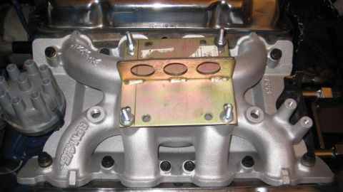 1968 Ford Ranchero - Close-up of an engine intake manifold with visible text and a metal bracket.