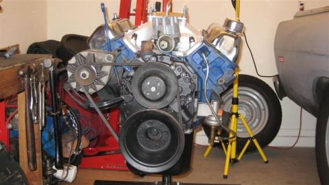 1968 Ford Ranchero - Engine assembly with blue valve covers and chrome accents, displayed on a stand in a workshop.