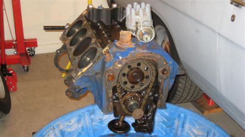 1968 Ford Ranchero - Disassembled engine block with timing gears and distributor cap visible. A vehicle is partially seen in the background.