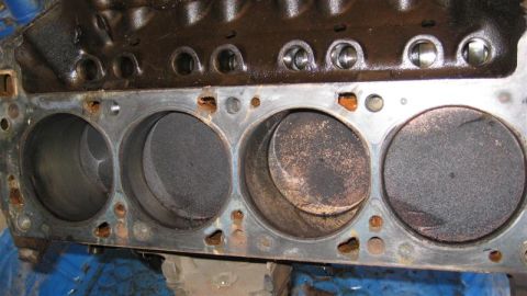 1968 Ford Ranchero - Close-up of an engine block's cylinders and pistons, indicating wear and carbon deposits.