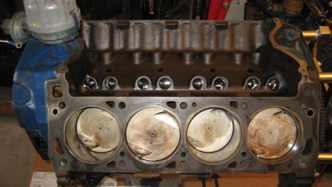 1968 Ford Ranchero - Close-up of an engine block's cylinders and pistons, with a blue distributor cap visible.
