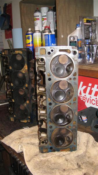 1968 Ford Ranchero - Engine cylinder heads are shown in a workshop setting with various spray cans in the background.