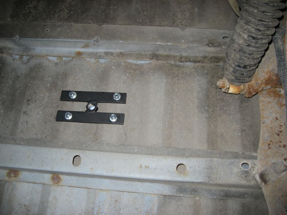 Underbody spare tire mount with bolts and a rubber boot