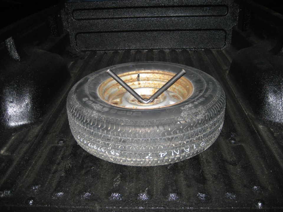 Spare tire with a jack in the bed of a pickup truck
