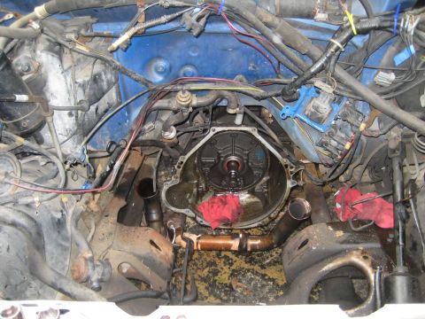 1988 Ford Bronco - The engine bay is exposed with the transmission removed, revealing the bell housing and associated wiring and plumbing.