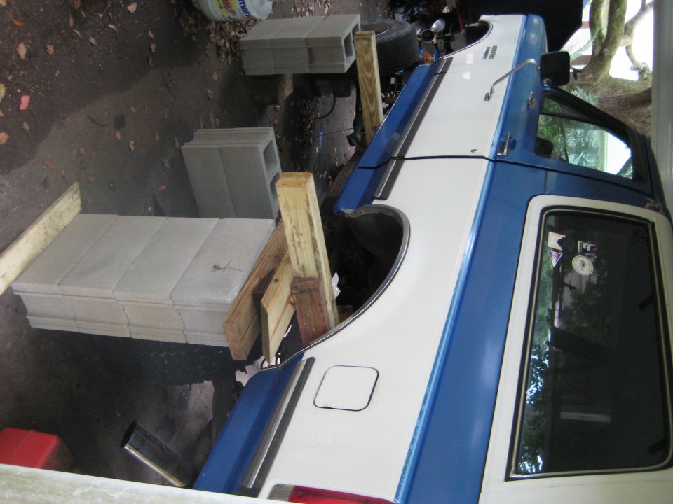 1988 Ford Bronco with wood and concrete blocks supporting the rear axle during repairs