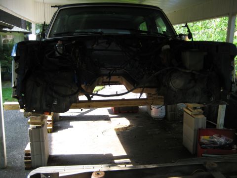 1988 Ford Bronco - Front view of a disassembled Ford Bronco, elevated for repairs, revealing its internal structure.