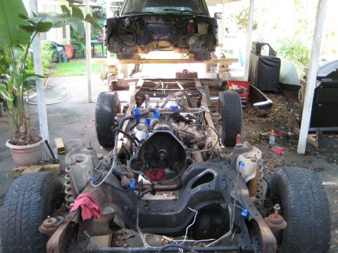 1988 Ford Bronco - Chassis of a vehicle undergoing repairs, with the engine and some body panels removed.