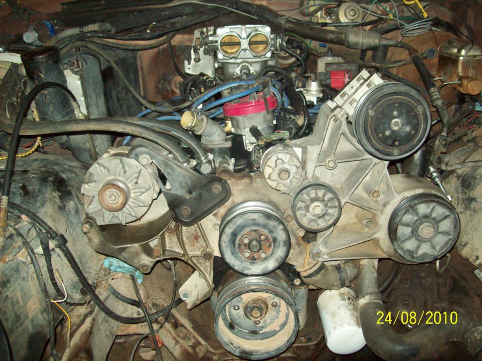 Engine bay with V8 engine, carburetor, and accessory belts