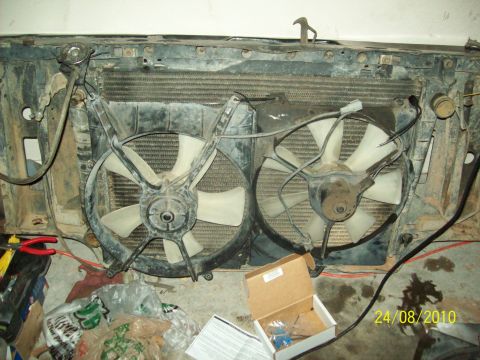 1985 Ford Bronco - Radiator and dual electric fans assembly, likely from a vehicle, with wiring and mounting hardware visible.