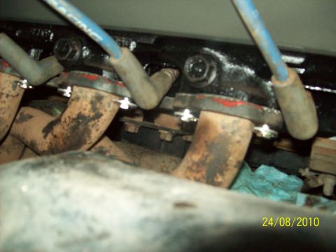 1985 Ford Bronco - Close-up view of engine exhaust manifold components and spark plug wires.